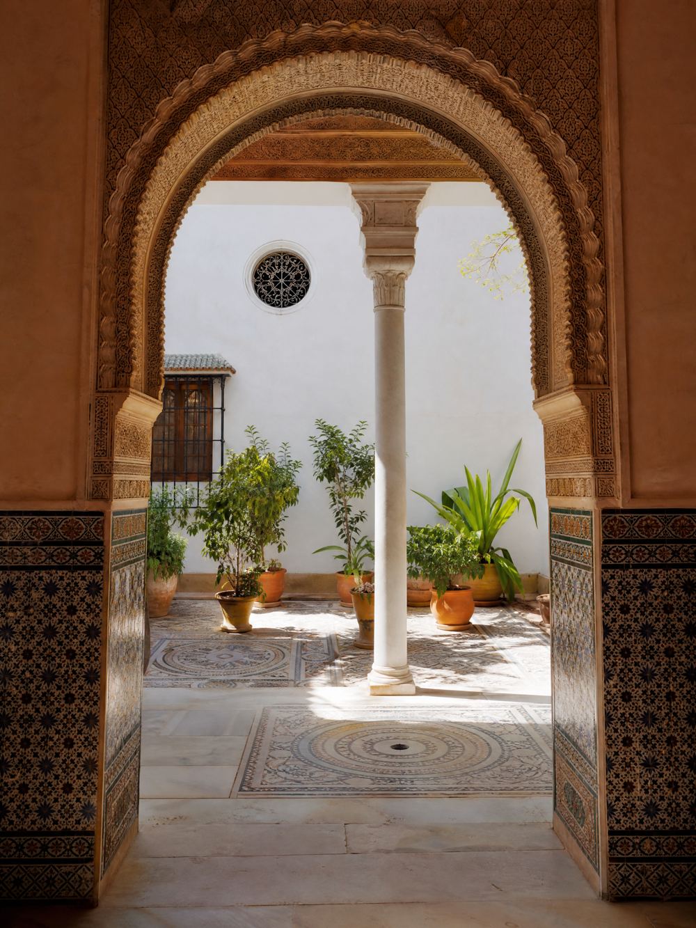 Vue à travers une arche sculptée sur le patio en mosaïque, Palais de Lebrija, Séville