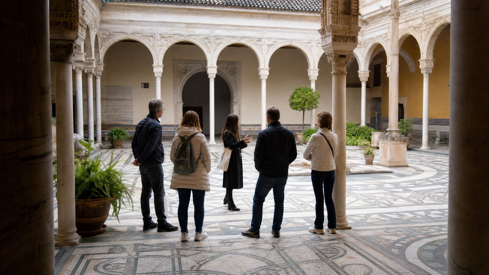 Small group with a guide in a Seville palace patio